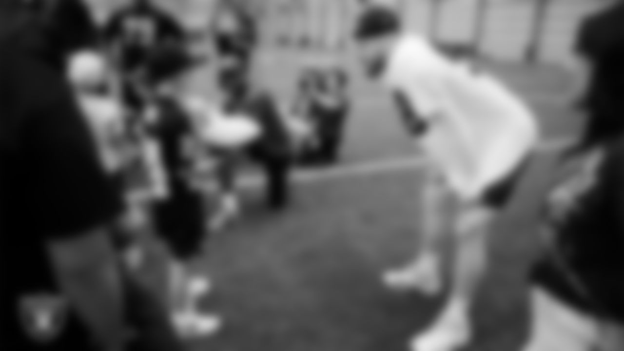 Las Vegas Raiders defensive end Maxx Crosby (98) speaks with Intermountain Children's Health patient Colston at Intermountain Health Performance Center.