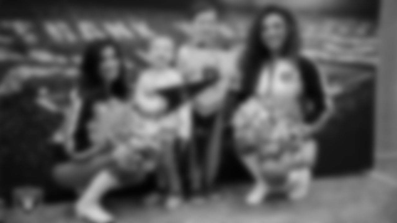 Raiderettes Tatiana and Lexie pose for a photo with children of a service member at Nellis Air Force Base.