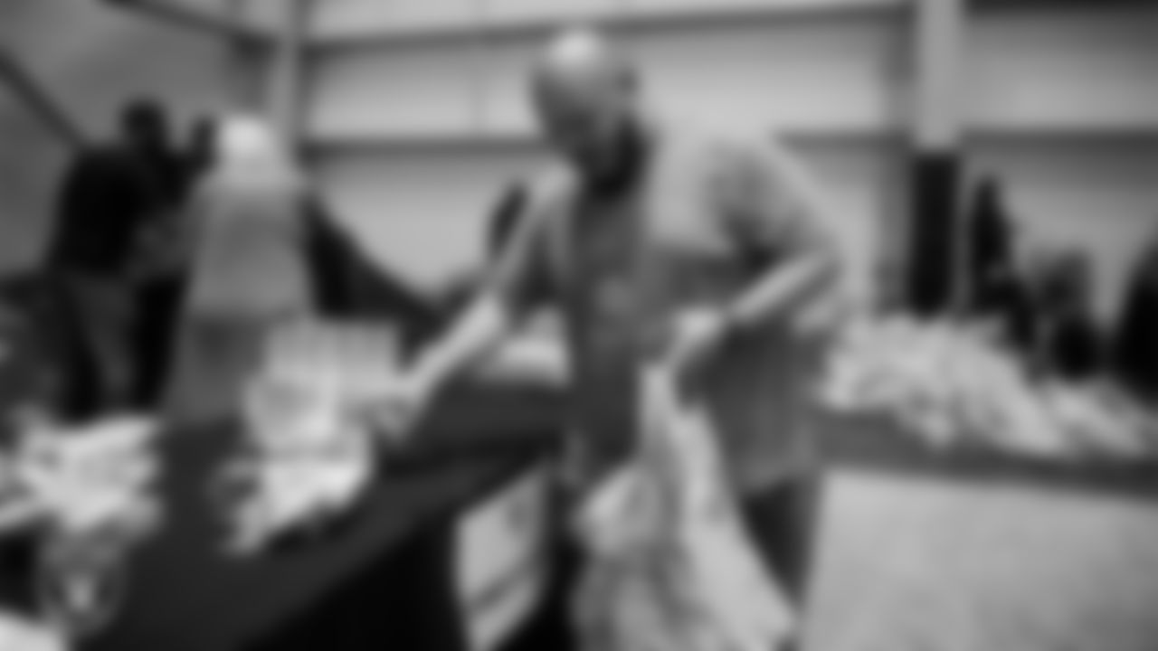 Las Vegas Raiders staff members help pack meals during the Raiders Holiday Meal Packing Party at Intermountain Health Performance Center.