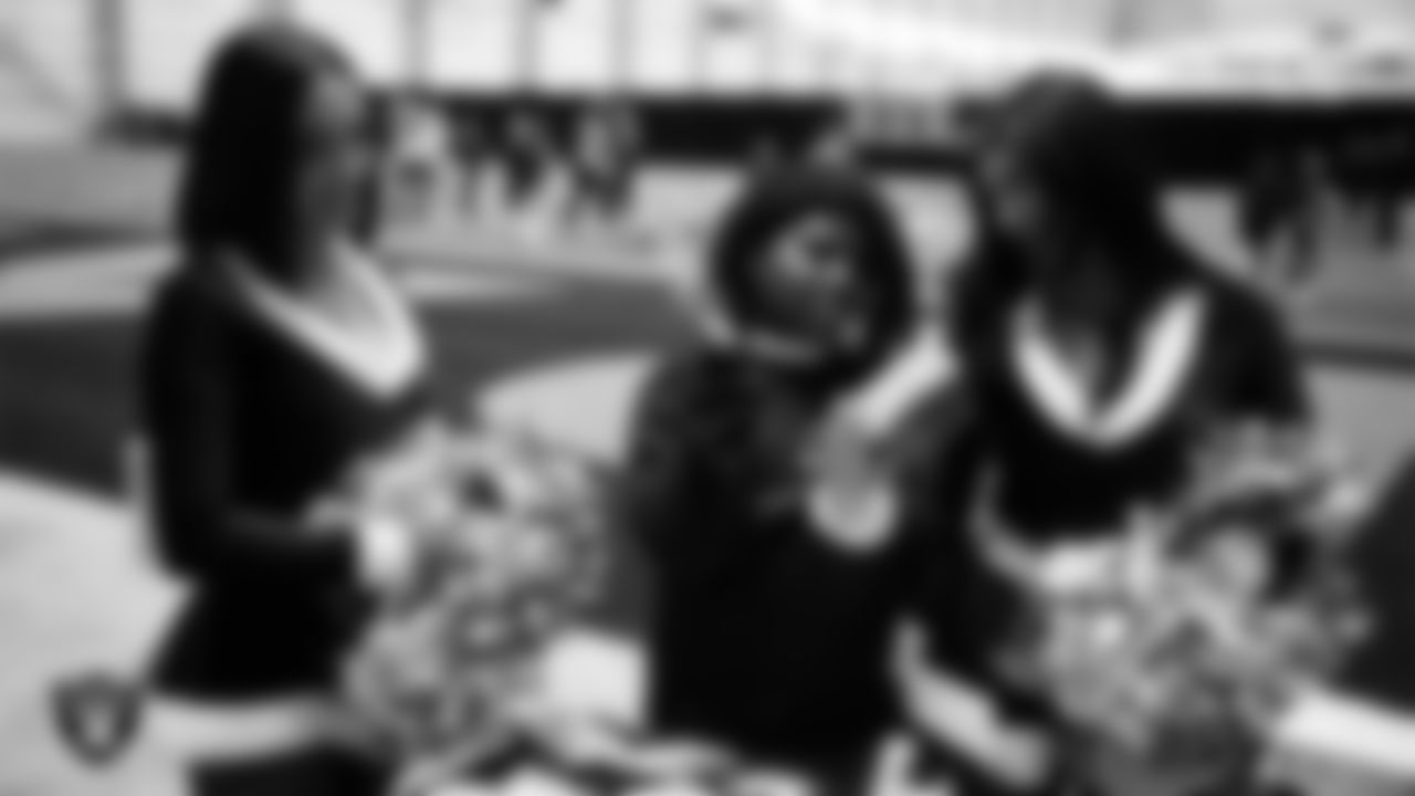 Raiderettes Kylie and Kylee help a student select toys during a Raiders Youth Holiday Party at Intermountain Health Performance Center.