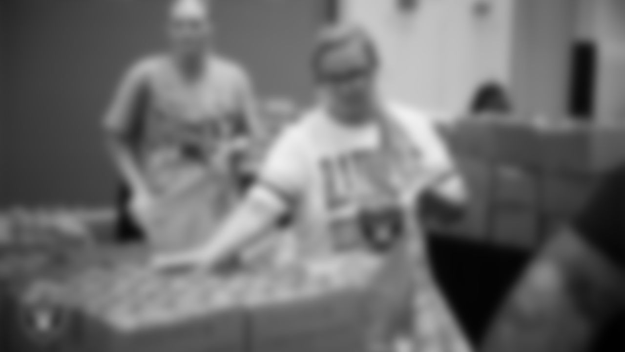 Las Vegas Raiders staff members help pack meals during the Raiders Holiday Meal Packing Party at Intermountain Health Performance Center.