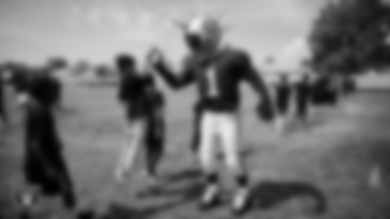 Raider Rusher high-fives a student during a Raiders Junior Training Camp at Berkeley Bunker Elementary School.