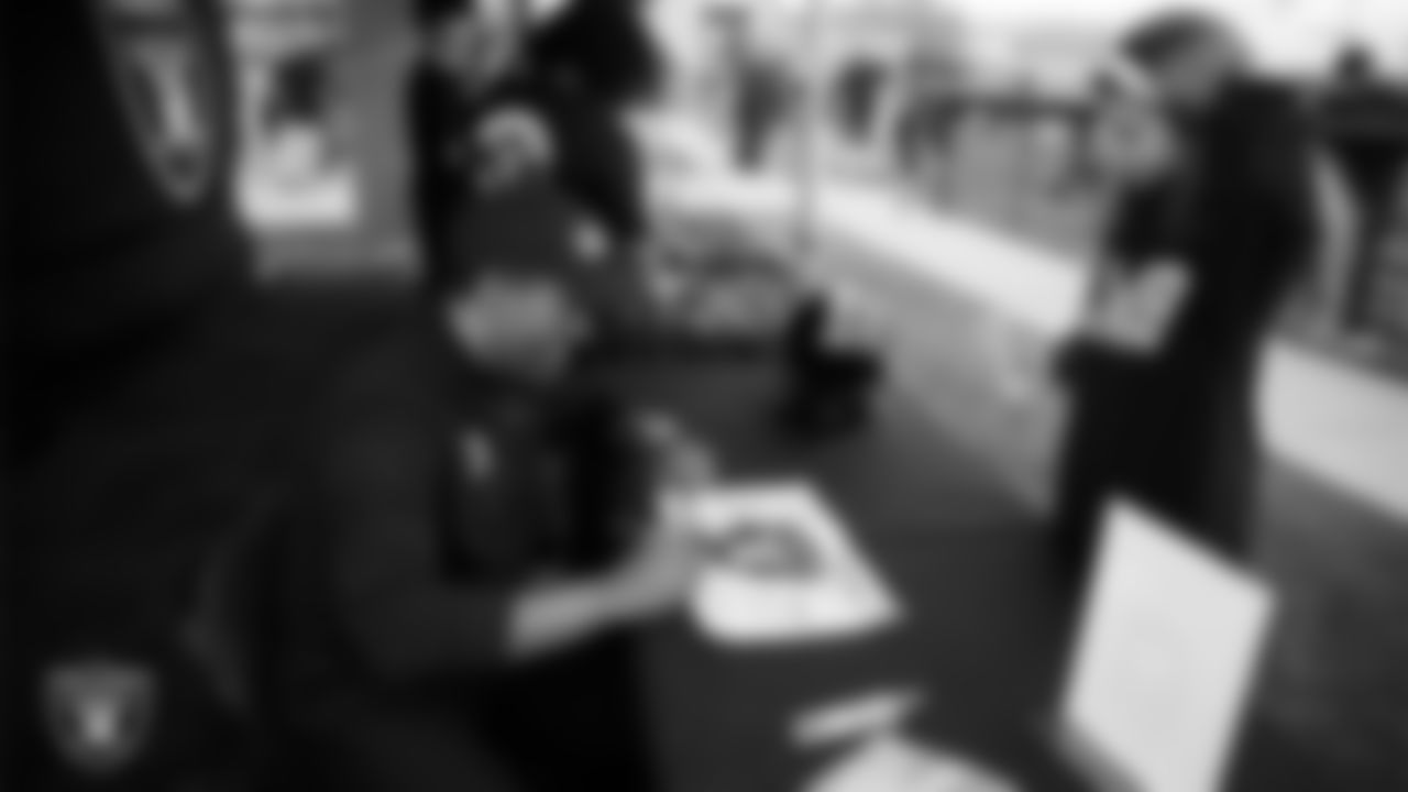 Las Vegas Raiders alumnus Leo Gray signs autographs before the Raiders' Football Showcase game at Faith Lutheran High School.