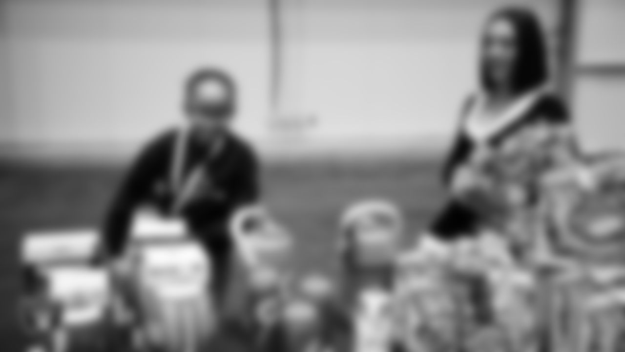 Raiderette Kylie helps a student select toys during a Raiders Youth Holiday Party at Intermountain Health Performance Center.