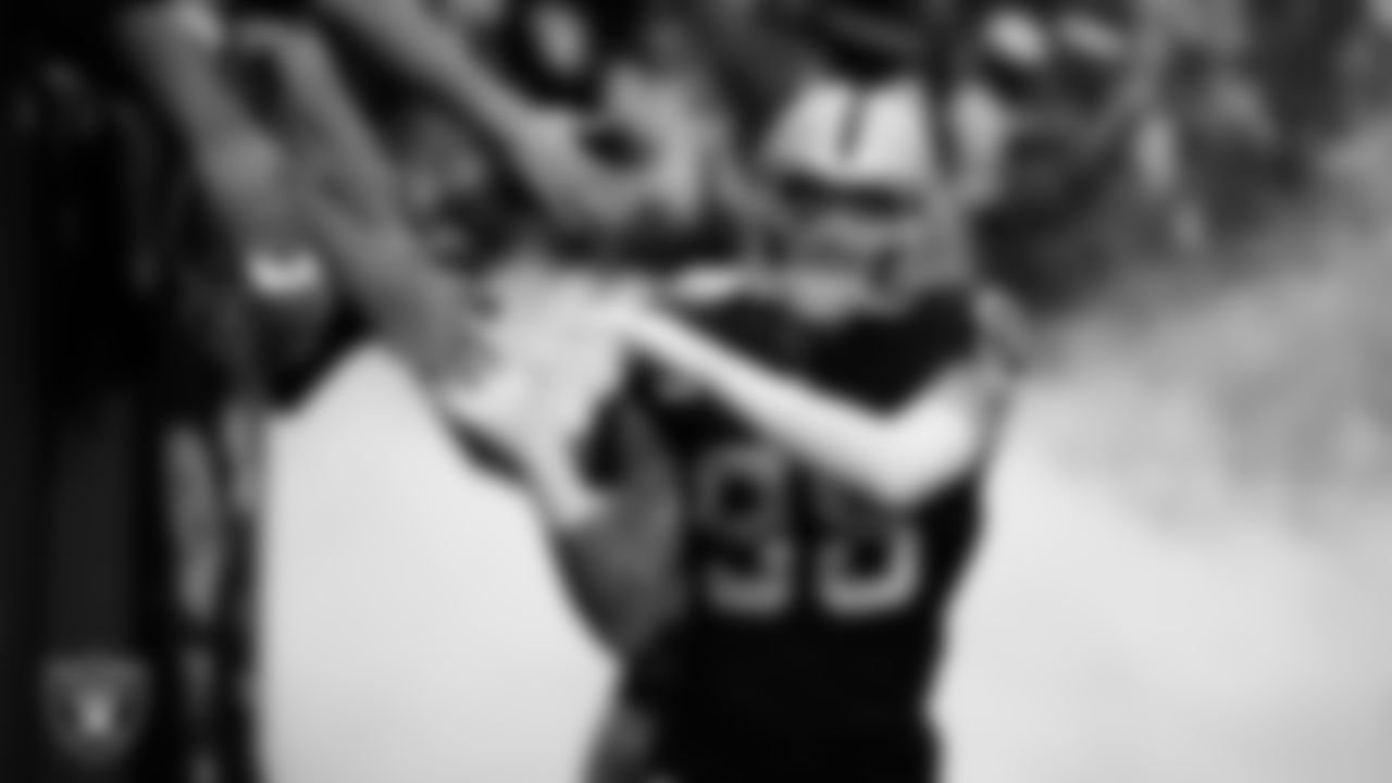 Las Vegas Raiders defensive end Maxx Crosby (98) high-fives fans before being introduced onto the field before the regular season home game against the Tennessee Titans at Allegiant Stadium.