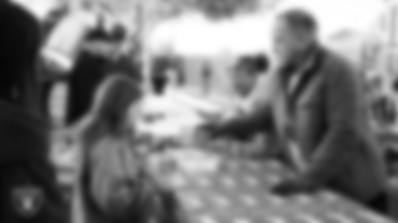 Volunteers hand out Sprite during the Raiders Holiday Salute at Nellis Air Force Base - Coral Academy.