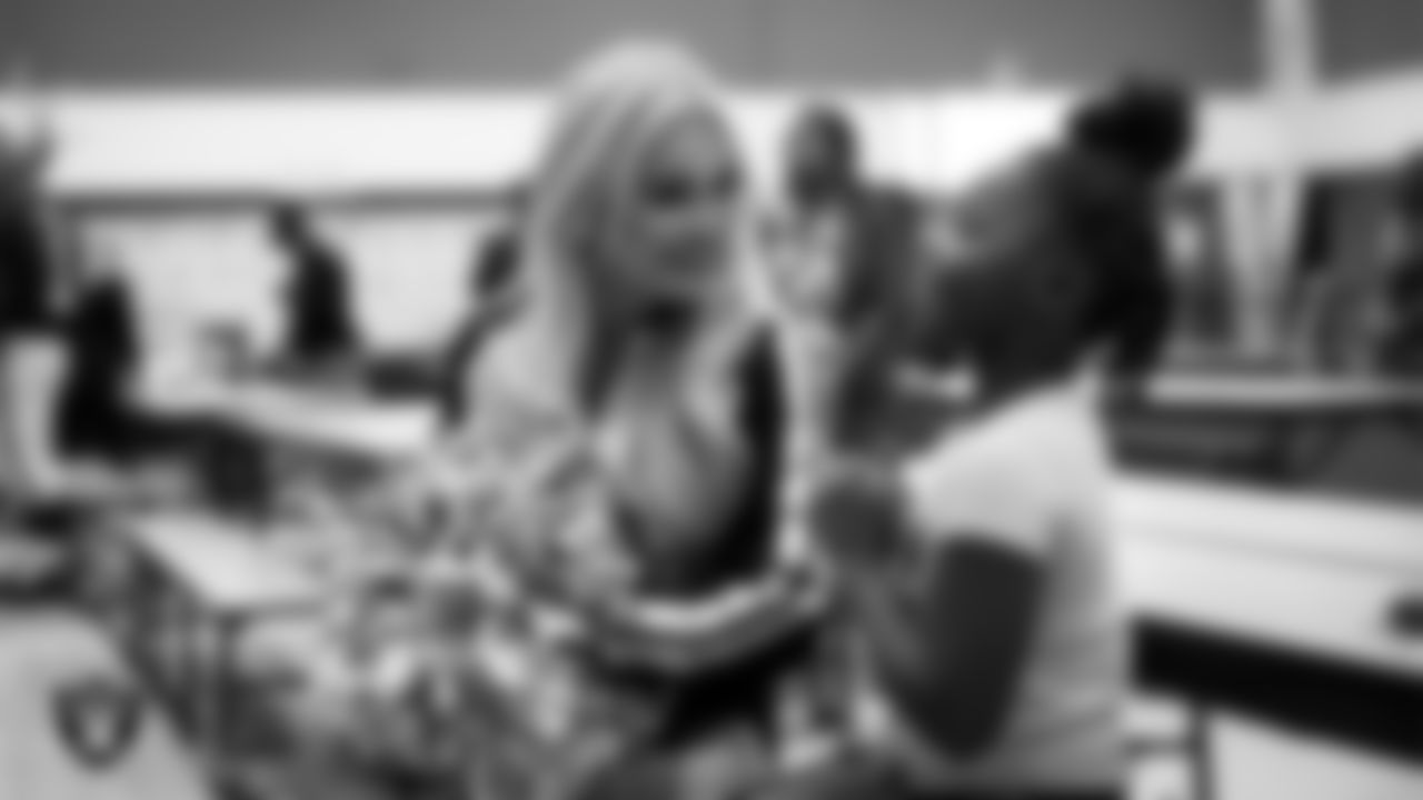 Raiderette Pip speaks to a student during a 'Lil Raiders Pop-Up at Matt Kelly Elementary School.