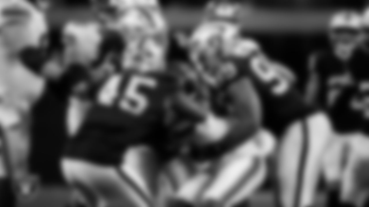 Las Vegas Raiders linebacker Devin White (45), defensive tackle Tonka Hemingway (97) and defensive tackle Thomas Booker IV (99) make a tackle during the regular season home game against the New York Giants at Allegiant Stadium.