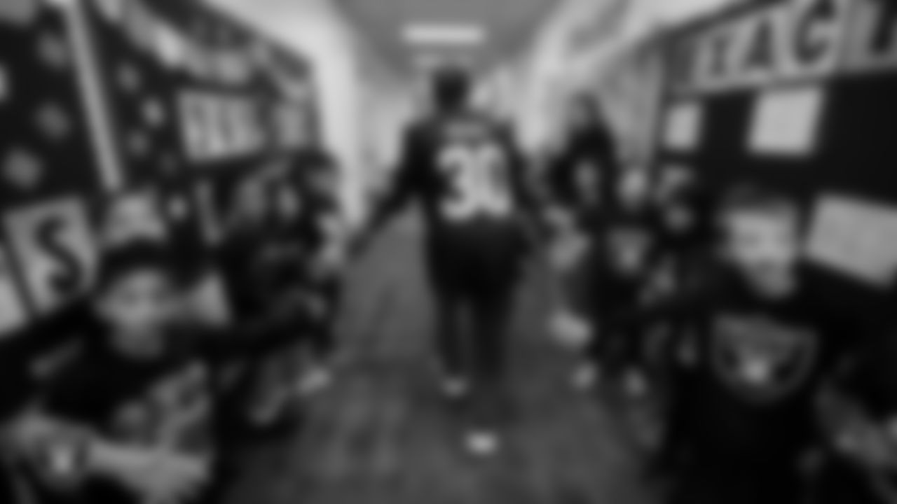 Las Vegas Raiders cornerback Darnay Holmes (30) greets students during a Raiders Spirit Day at Richard H. Bryan Elementary School.