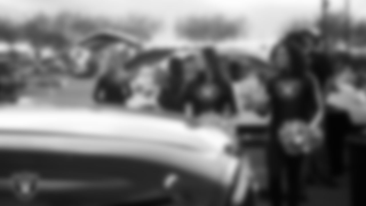 Raiderettes Cheyanne and Makenna wave to attendees during Turkey Time with the O-Line at Allegiant Stadium.