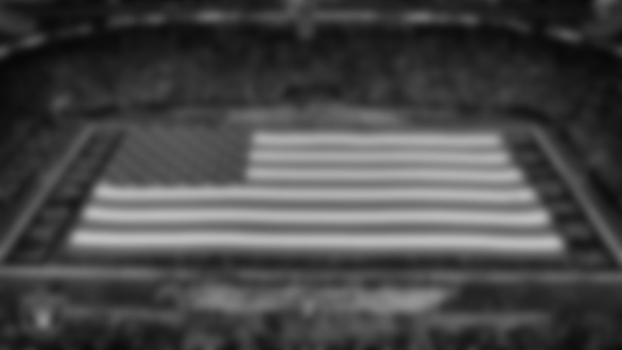 The American flag is displayed by Personal Seat License (PSL) holders on the field during the national anthem before the Las Vegas Raiders' regular season home game against the Los Angeles Chargers at Allegiant Stadium.
