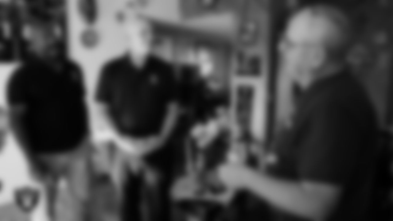 United States Navy Veteran Michael Royal speaks with Las Vegas Raiders alumni Napoleon McCallum and Jay Schroeder after being surprised with tickets to the Raiders' Salute to Service game.