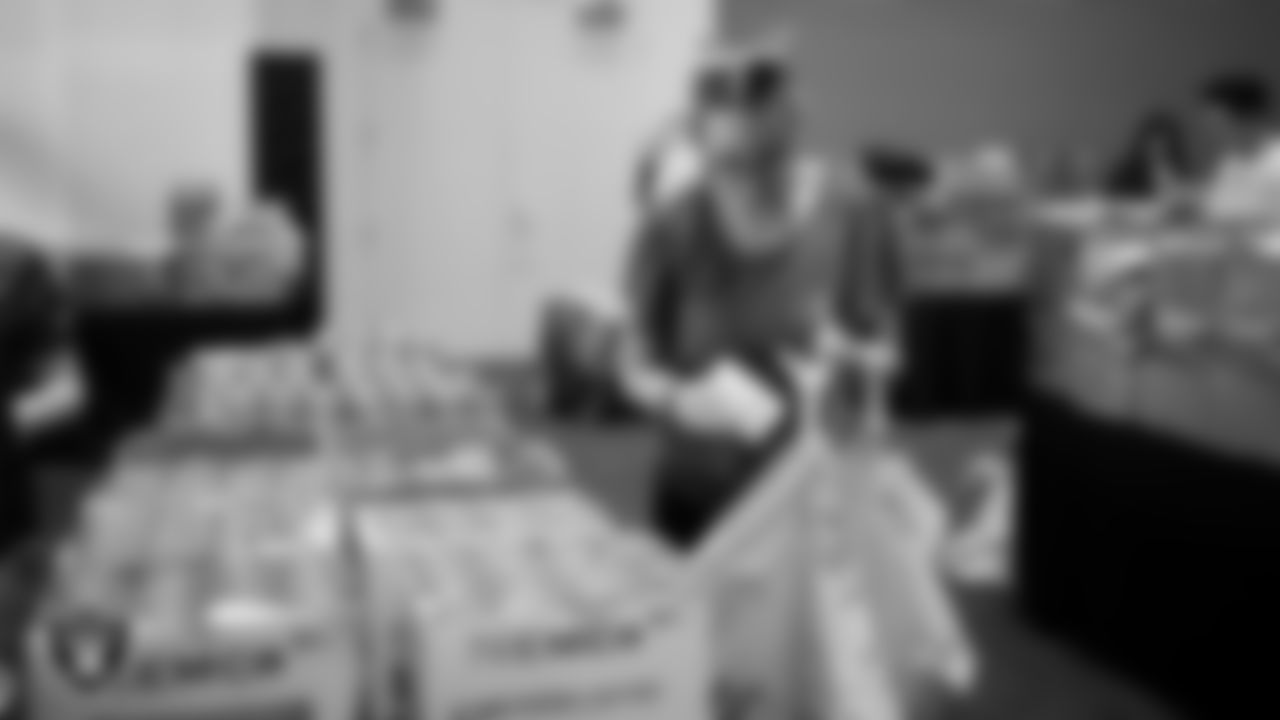 Las Vegas Raiders staff members help pack meals during the Raiders Holiday Meal Packing Party at Intermountain Health Performance Center.