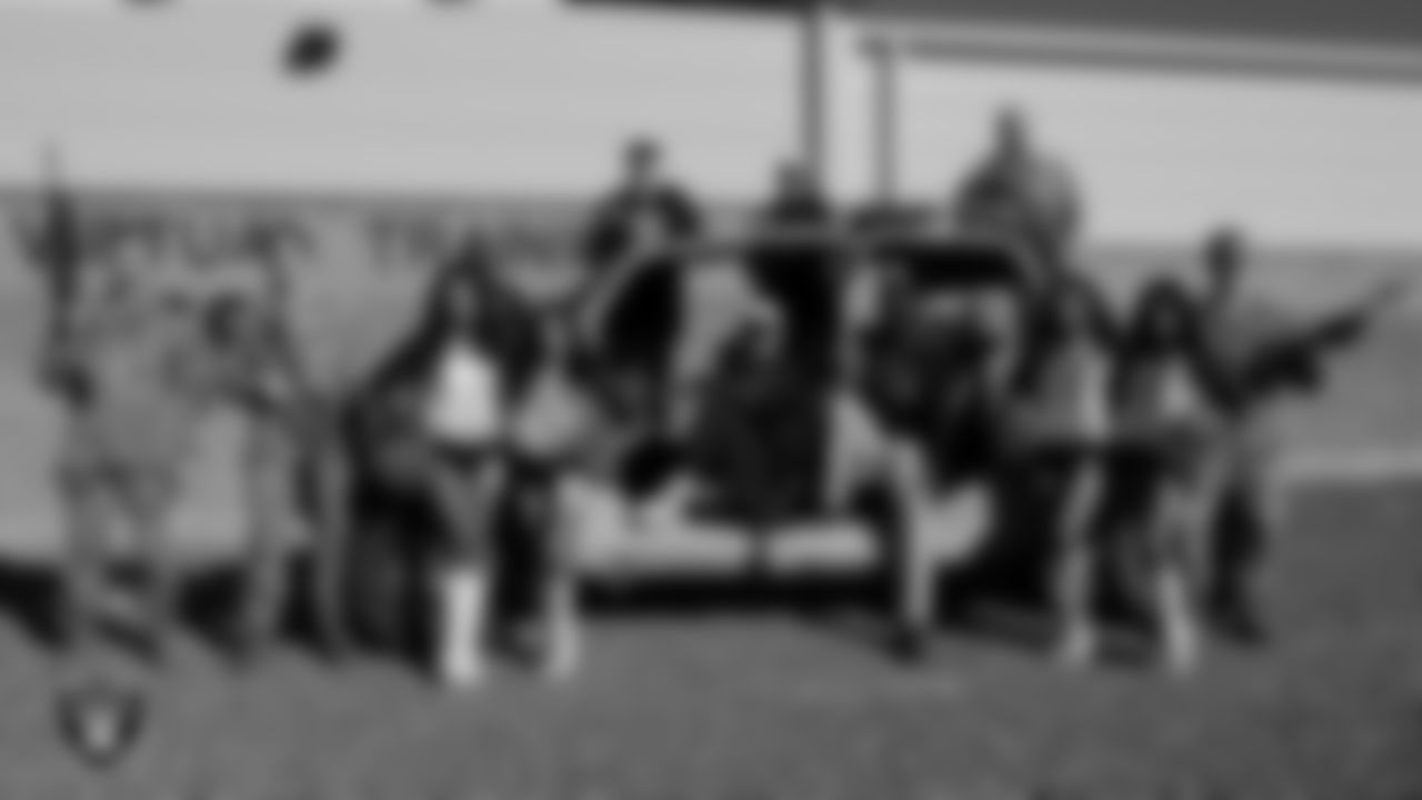 Las Vegas Raiders players, alumni and Raiderettes pose for a photo with service members during a tour of Nellis Air Force Base.