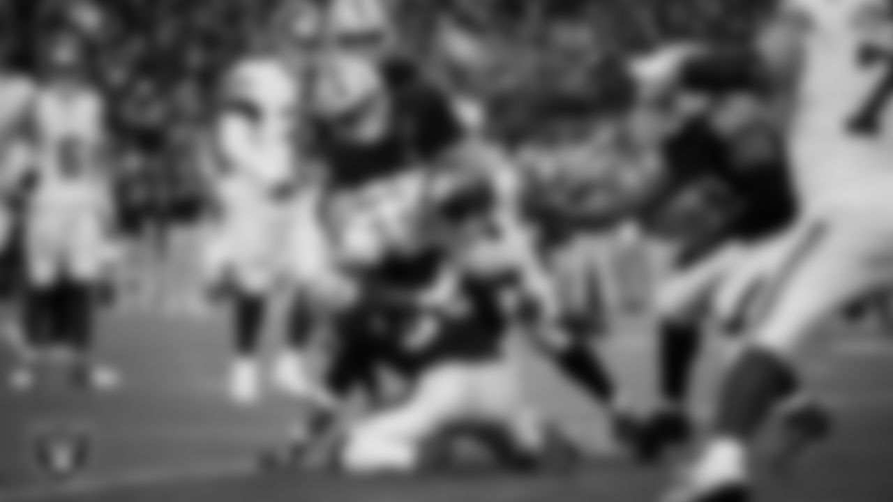 Las Vegas Raiders linebacker Jamal Adams (33) and defensive tackle Jonah Laulu (96) make a tackle during the regular season home game against the New York Giants at Allegiant Stadium.