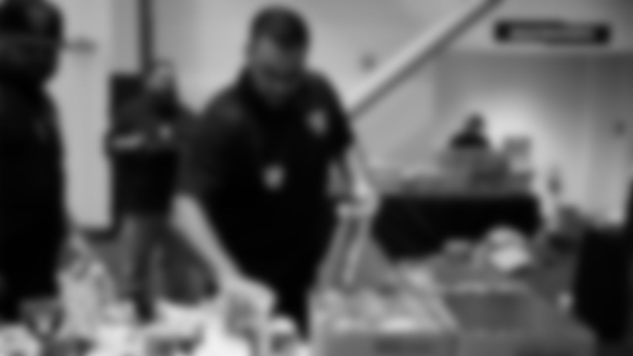 Las Vegas Raiders staff members help pack meals during the Raiders Holiday Meal Packing Party at Intermountain Health Performance Center.