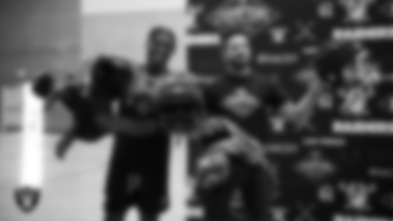 Las Vegas Raiders safety Thomas Harper (34) and attorney Farhan Naqvi of Naqvi Injury Law surprise athletes with new equipment at Legacy High School.