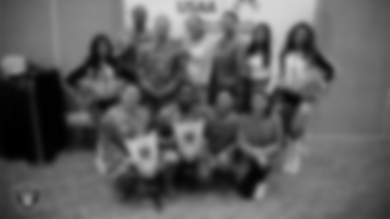 Raiderettes Tatiana and Lexie pose for a photo with service members at Nellis Air Force Base.