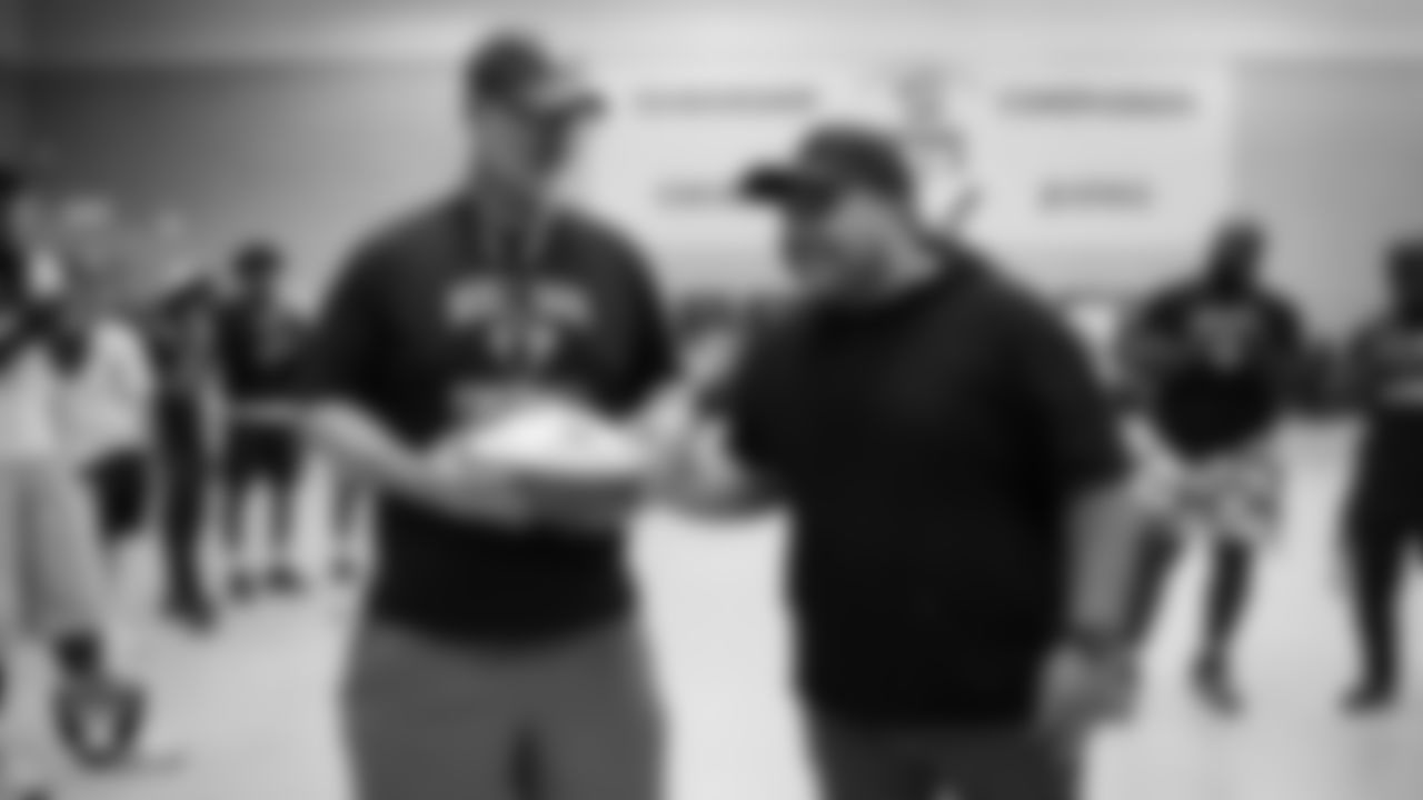 Las Vegas Raiders senior manager of football development Jordan Aguilar presents Desert Oasis High School football coach Matt Rosdahl with the Tom Flores Coach of the Week custom football during practice at Desert Oasis High School.