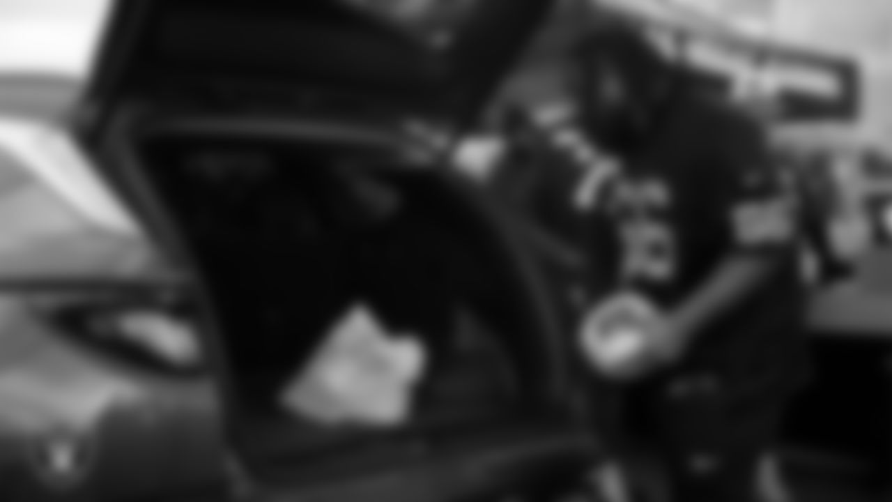 Las Vegas Raiders guard Dylan Parham (66) helps distribute Thanksgiving meals to families during Turkey Time with the O-Line at Allegiant Stadium.