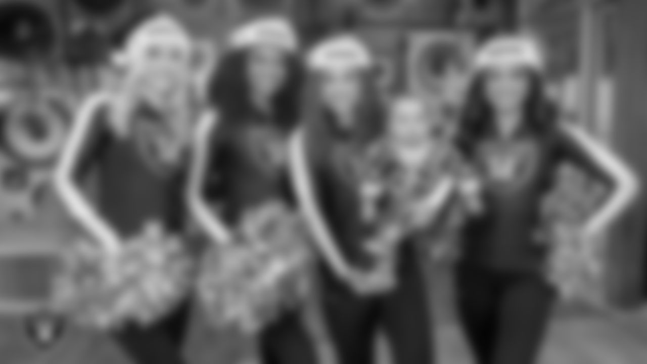 Raiderettes Kennedy, Shayla, Lexie and Sloane pose for a photo with an attendee during a toy drive at Intermountain Health Primary Children's Hospital.