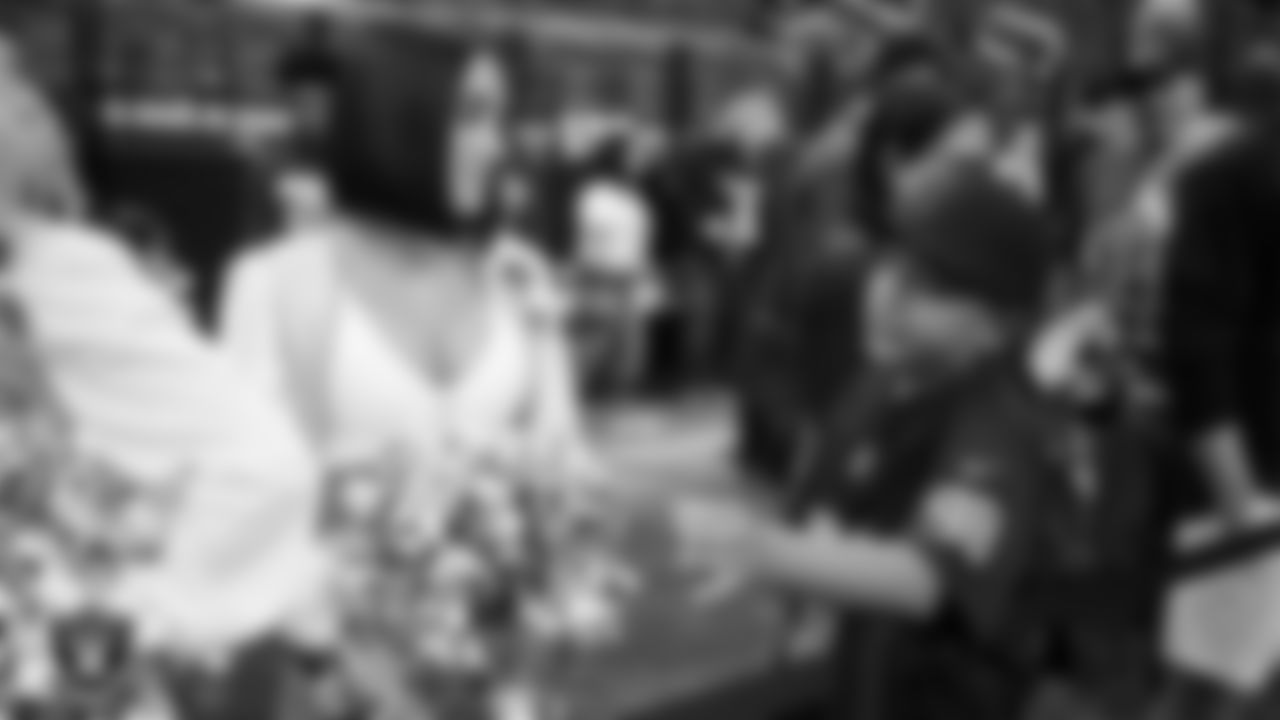 Raiderette Kylie talks with Christopher Arias from Make-A-Wish on the sidelines before the Las Vegas Raiders' regular season home game against the Jacksonville Jaguars at Allegiant Stadium.