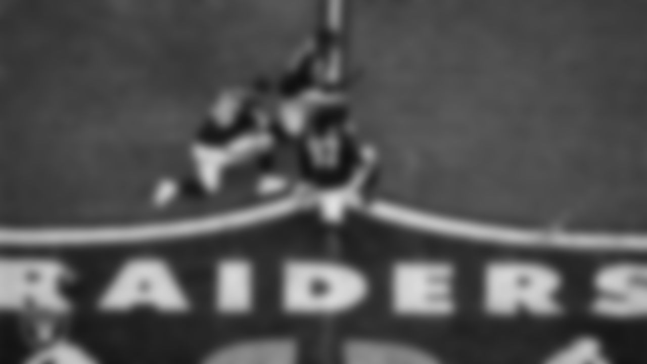 Las Vegas Raiders defensive tackle Jonah Laulu (96), defensive end Tyree Wilson (9) and defensive tackle Tonka Hemingway (97) kneel on the field during the regular season home game against the Denver Broncos at Allegiant Stadium.