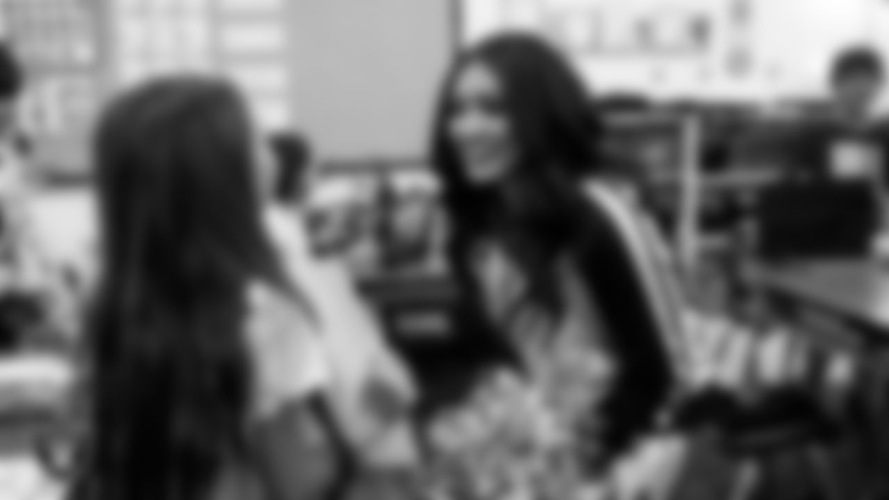 Raiderette Sloane speaks to a student during a 'Lil Raiders Pop-Up at Richard H. Bryan Elementary School.