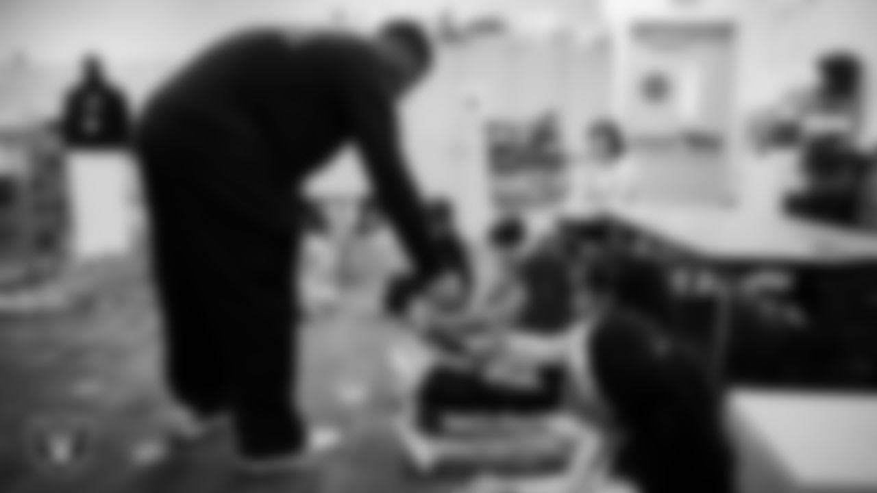 Las Vegas Raiders coordinator of football development Chris Shelby hands out stickers to students at Richard H. Bryan Elementary School.