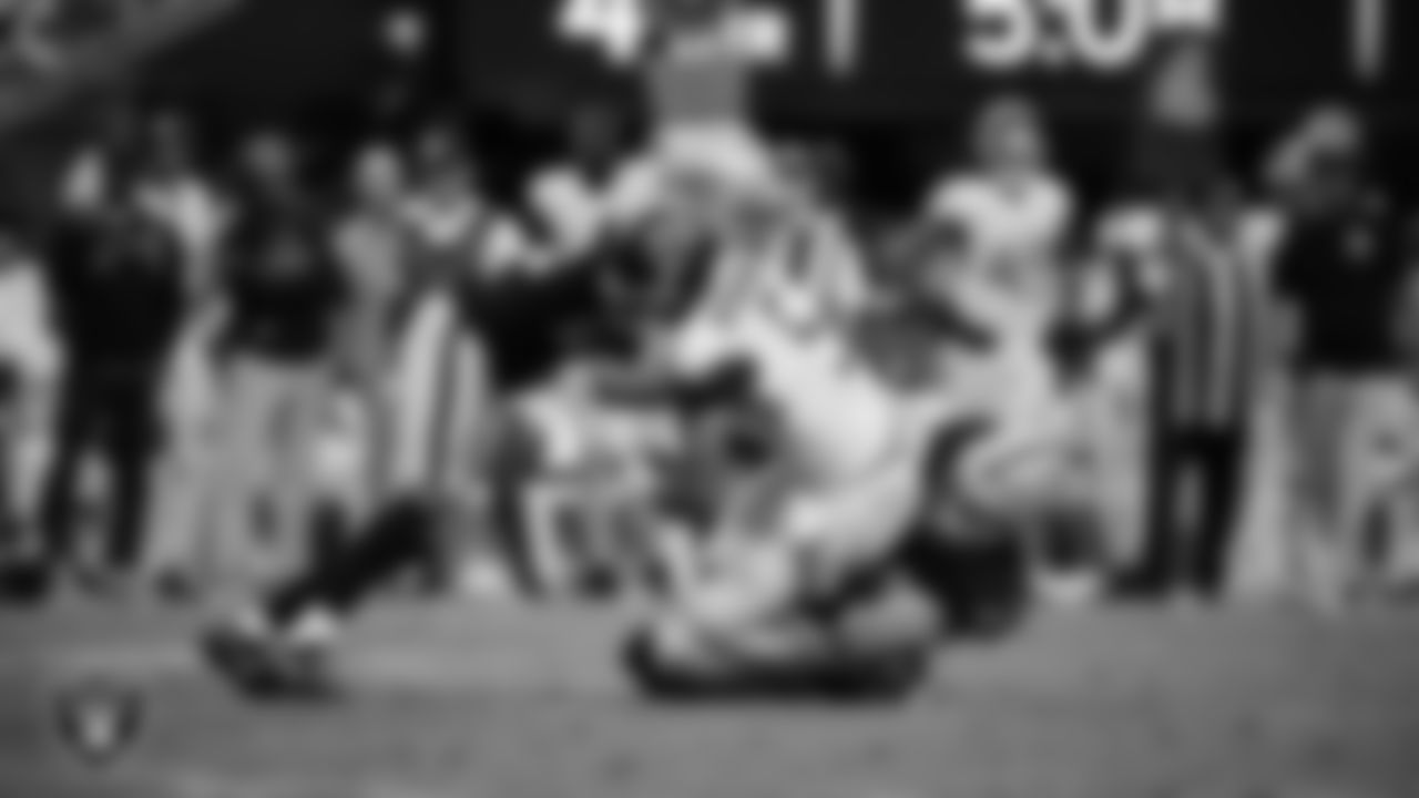 Las Vegas Raiders cornerback Eric Stokes (22) and linebacker Tommy Eichenberg (44) make a tackle during the regular season home game against the Tennessee Titans at Allegiant Stadium.