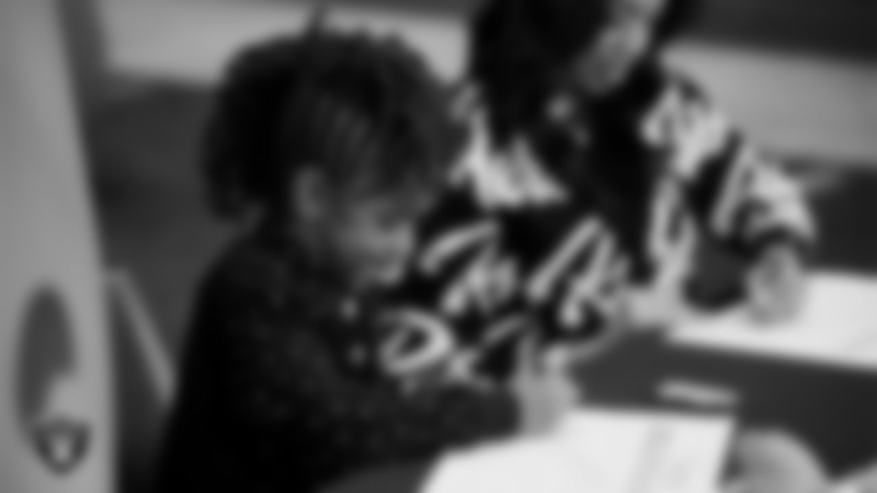 Las Vegas Raiders President Sandra Douglass Morgan designs custom shoes for My Cause My Cleats with Intermountain Children's Health patient Evelyn at Intermountain Health Performance Center.