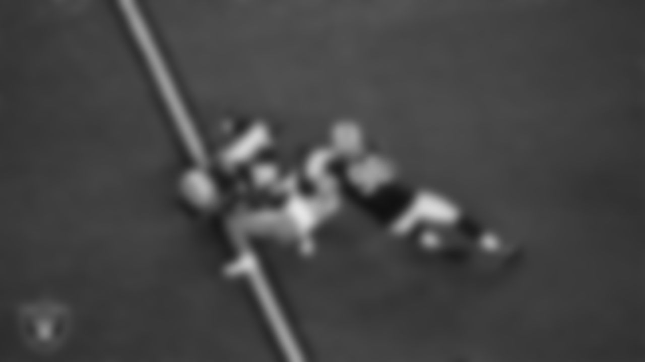 Las Vegas Raiders linebacker Devin White (45) and defensive end Maxx Crosby (98) make a tackle during the regular season home game against the Los Angeles Chargers at Allegiant Stadium.