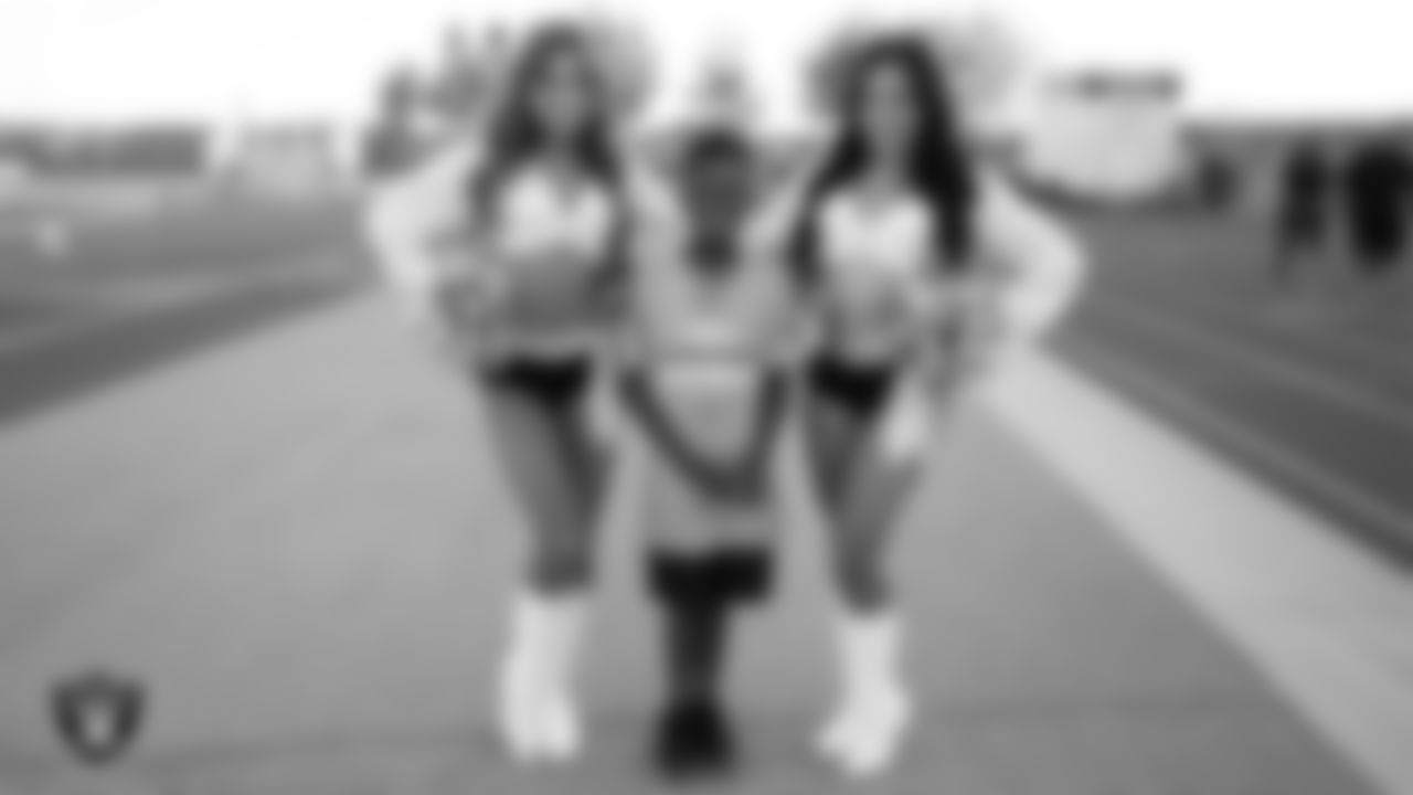 Raiderettes Audrey and Jenna H. pose for a photo with a fan before the Las Vegas Raiders' Football Showcase game between Sierra Vista High School and Green Valley High School at Sierra Vista High School.