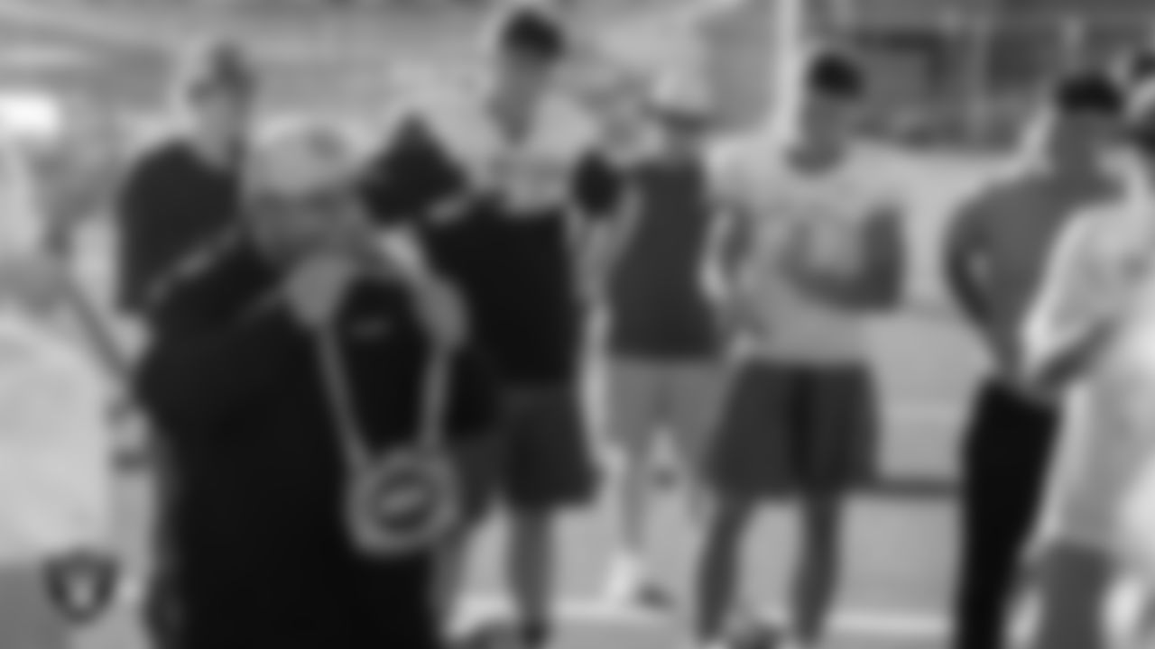 Las Vegas Raiders senior manager of football development Jordan Aguilar shows off the Las Vegas Raiders' Football Showcase MVP chain to the Moapa Valley High School football team during practice at Moapa Valley High School.