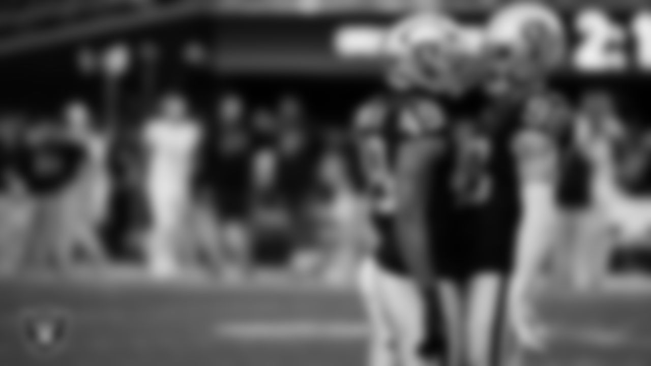 Las Vegas Raiders defensive end Maxx Crosby (98) celebrates with defensive end Charles Snowden (49) after sacking the quarterback during the regular season home game against the Tennessee Titans at Allegiant Stadium.