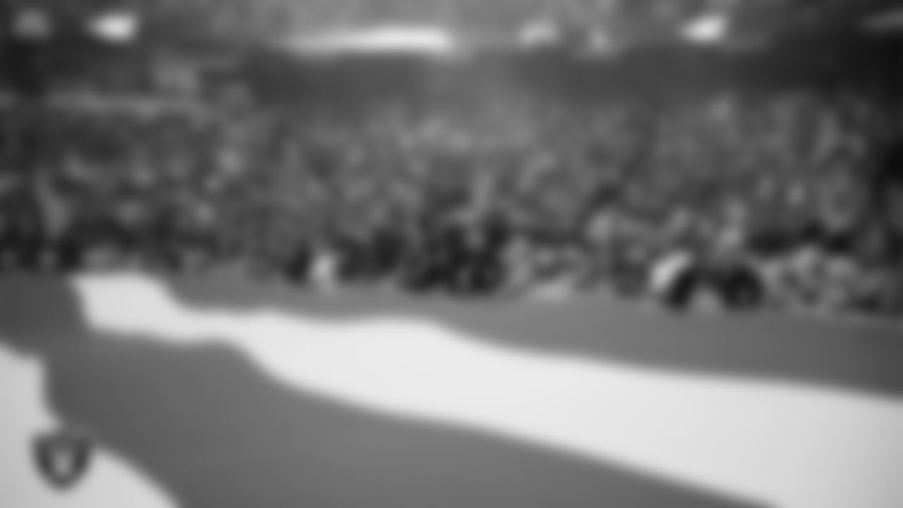 The American flag is displayed by Personal Seat License (PSL) holders on the field during the national anthem before the Las Vegas Raiders' preseason home game against the San Francisco 49ers at Allegiant Stadium.