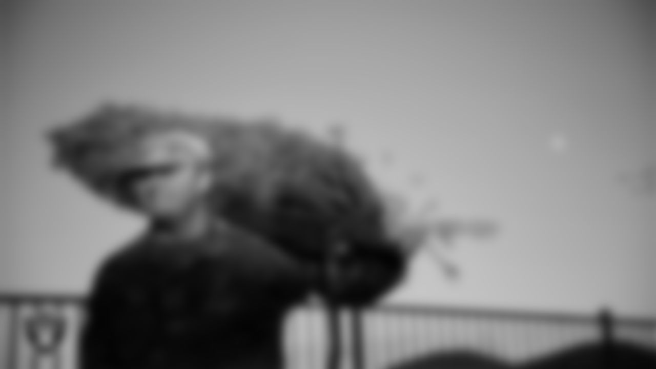 An Air Force member picks out a tree during the Raiders Holiday Salute at Nellis Air Force Base - Coral Academy.