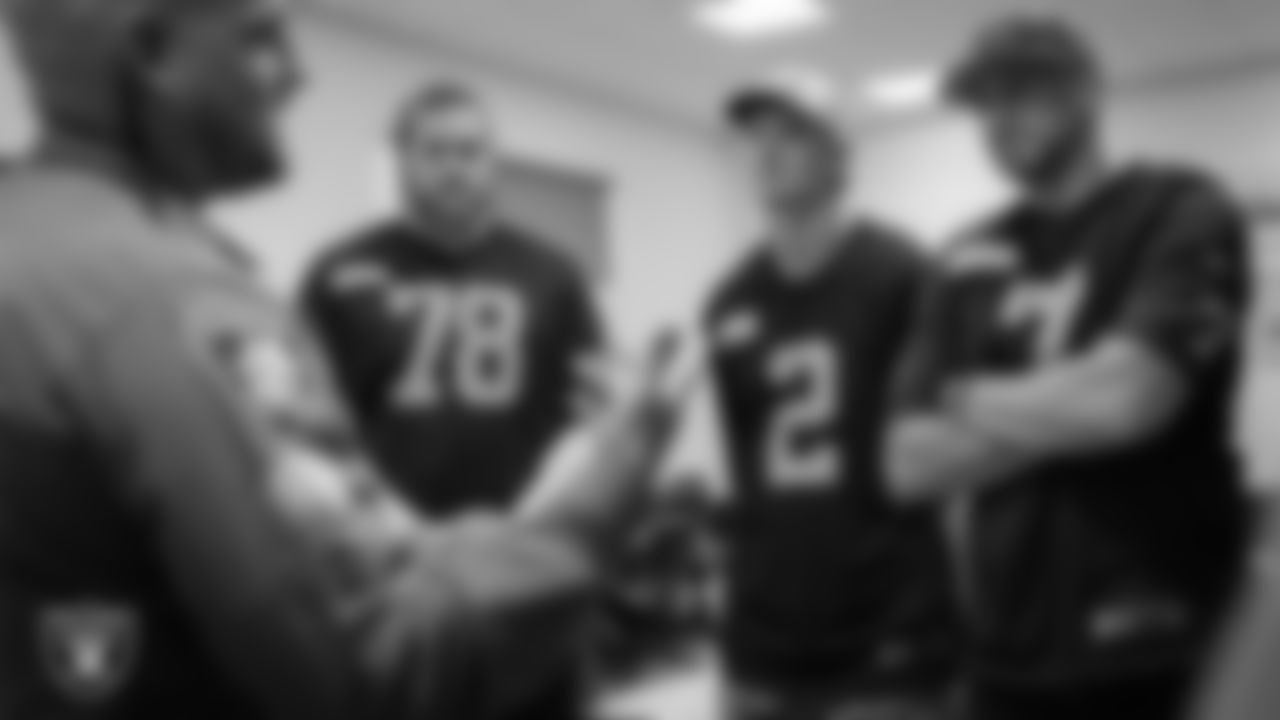 Las Vegas Raiders tackle Dalton Wagner (78), kicker Daniel Carlson (2) and quarterback Brian Hoyer (7) speak with an officer during a visit to William Fortye K-9 Operations Center.