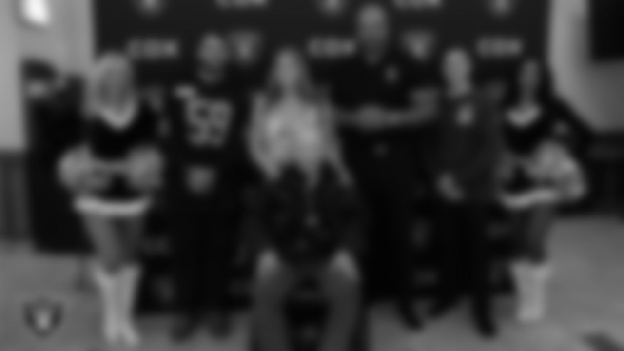 Las Vegas Raiders linebacker Jon Rhattigan (59), alumnus Grant Irons, Raider Nation Radio host Vince Sapienza and Raiderettes Kennedy and Cierra pose for a photo with a veteran during the annual Cox Salute to Service Tailgate at Southern Nevada State Veterans Home.