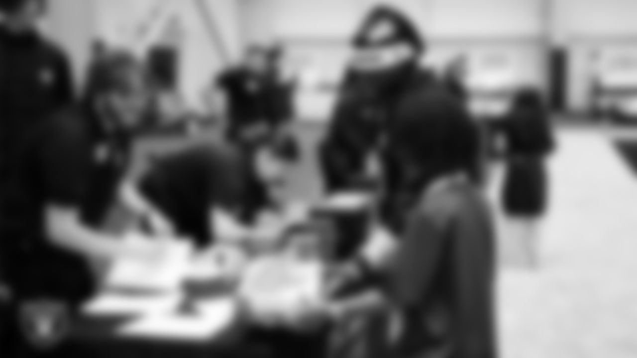 Las Vegas Raiders running back Ashton Jeanty (2) helps a student select toys during a Raiders Youth Holiday Party at Intermountain Health Performance Center.