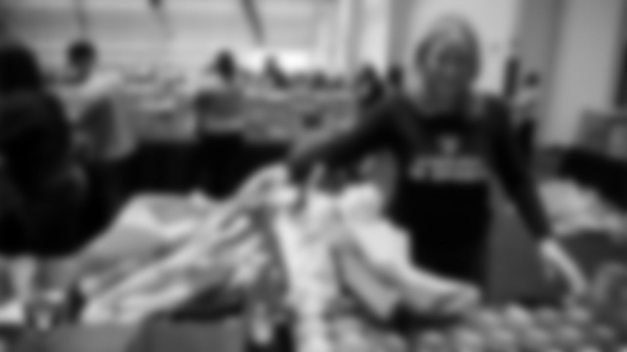 Las Vegas Raiders staff members help pack meals during the Raiders Holiday Meal Packing Party at Intermountain Health Performance Center.