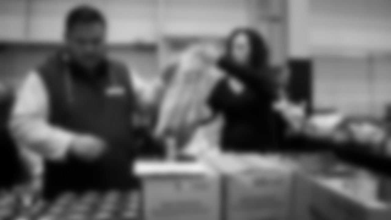 Las Vegas Raiders staff members help pack meals during the Raiders Holiday Meal Packing Party at Intermountain Health Performance Center.