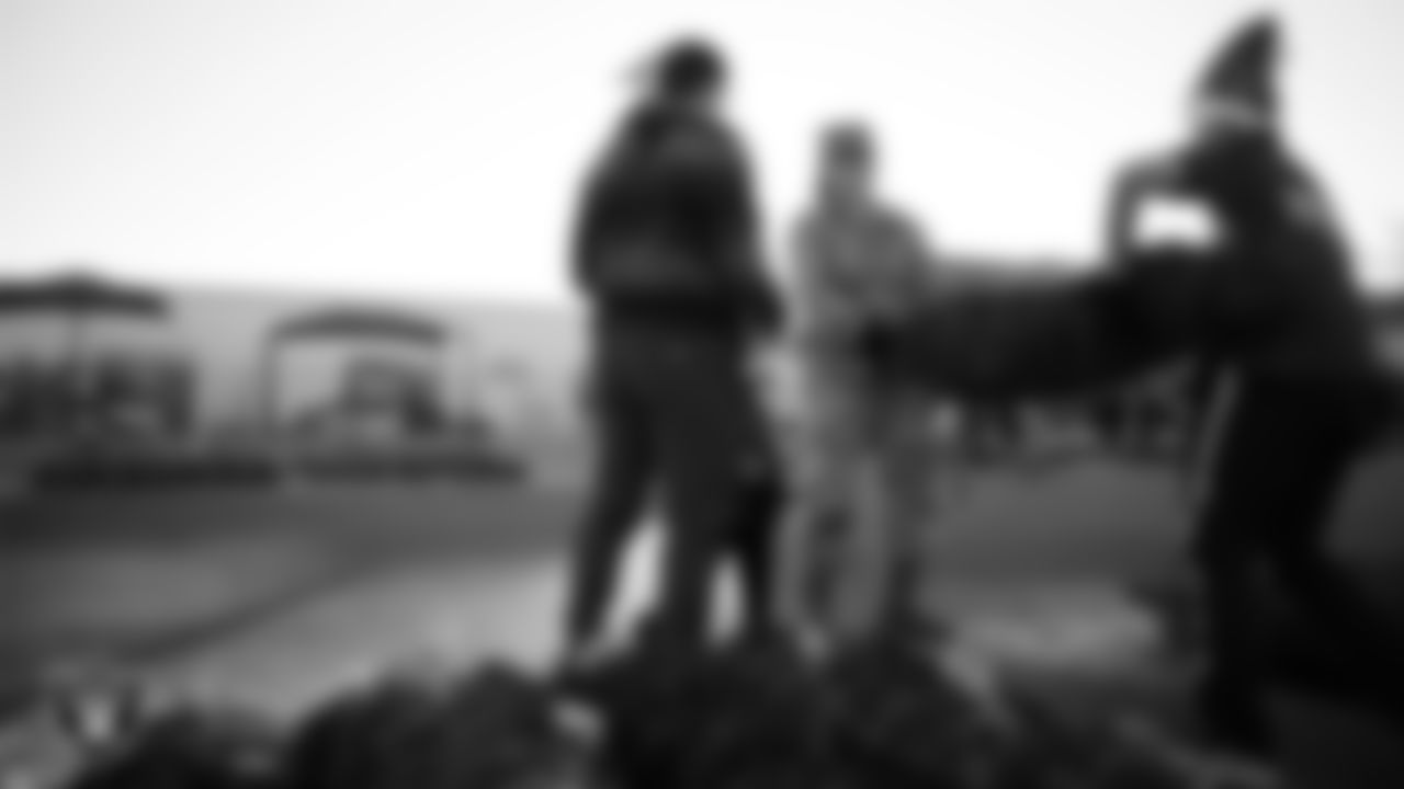 Air Force members and their families pick out a tree during the Raiders Holiday Salute at Nellis Air Force Base - Coral Academy.