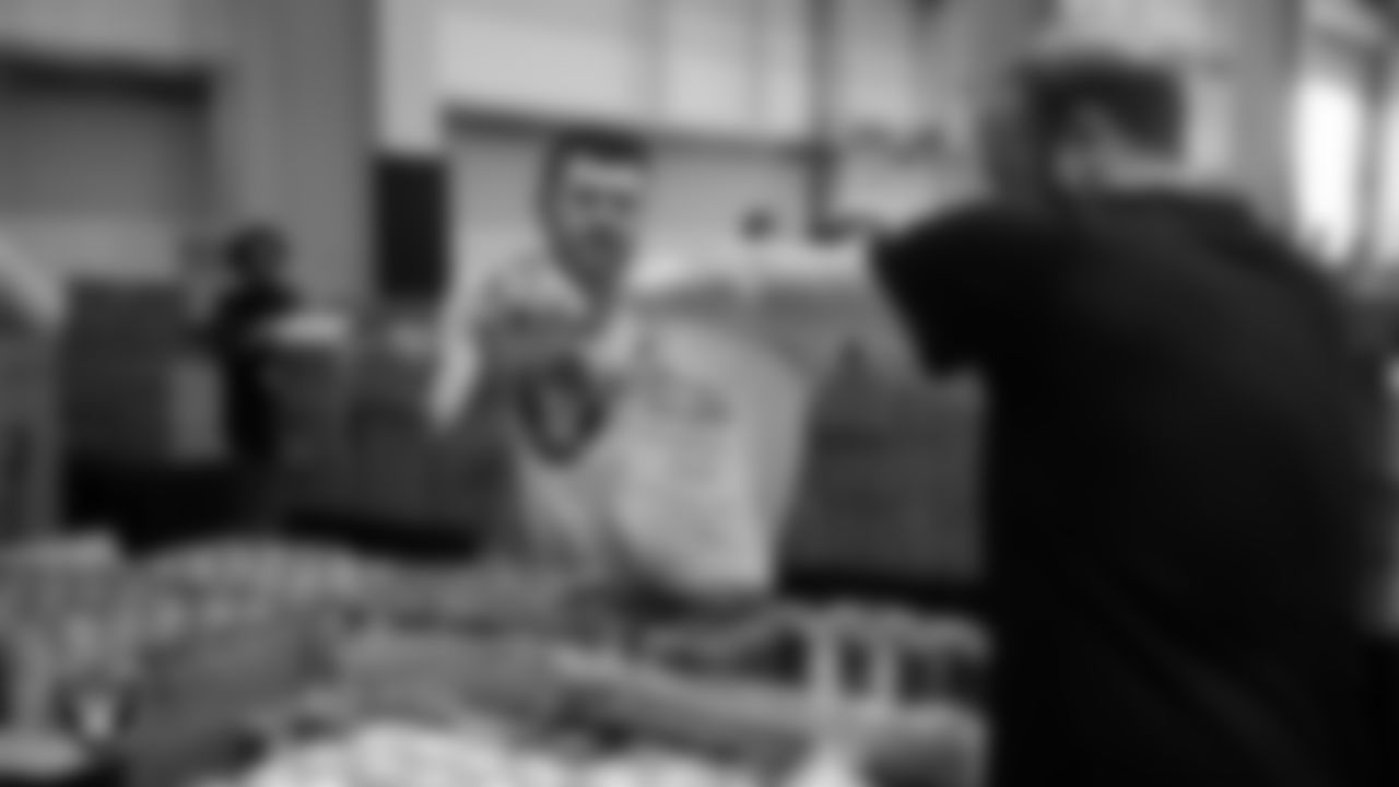 Las Vegas Raiders staff members help pack meals during the Raiders Holiday Meal Packing Party at Intermountain Health Performance Center.
