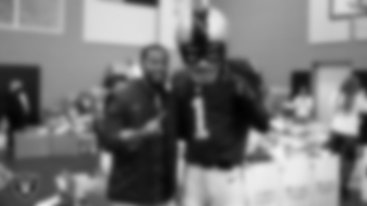 Raider Rusher poses for a photo with Clark County Commissioner William McCurdy II during the NFL Green's Super Kids-Super Sharing event at the Pearson Community Center.