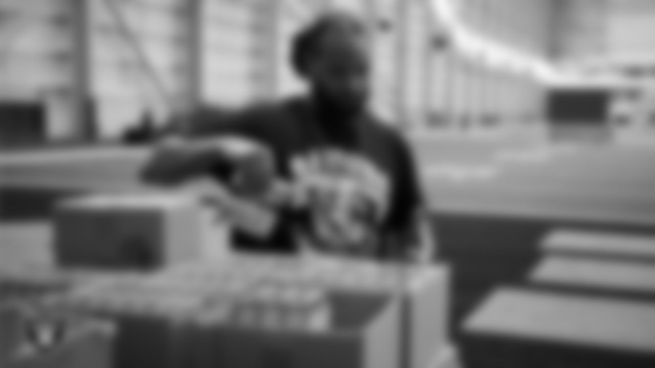 Las Vegas Raiders staff members help pack meals during the Raiders Holiday Meal Packing Party at Intermountain Health Performance Center.