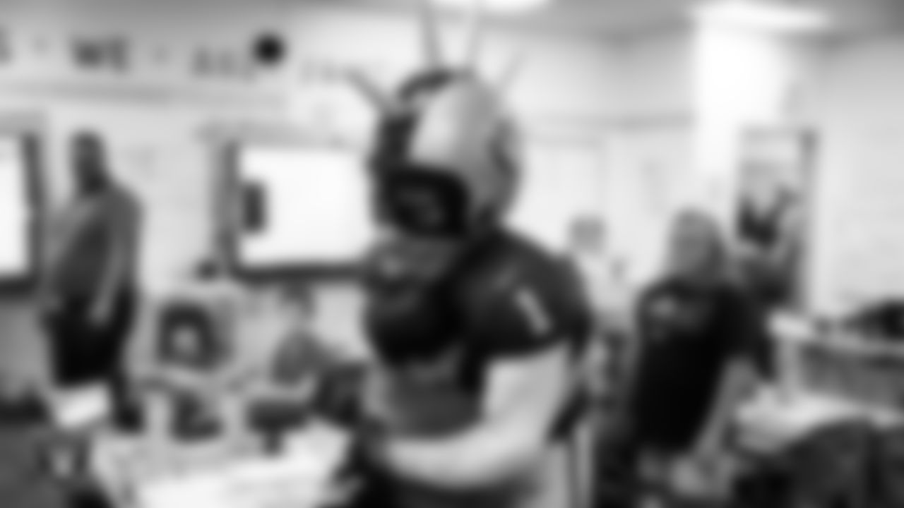 Raider Rusher hugs a student during a 'Lil Raiders Pop-Up at Richard H. Bryan Elementary School.