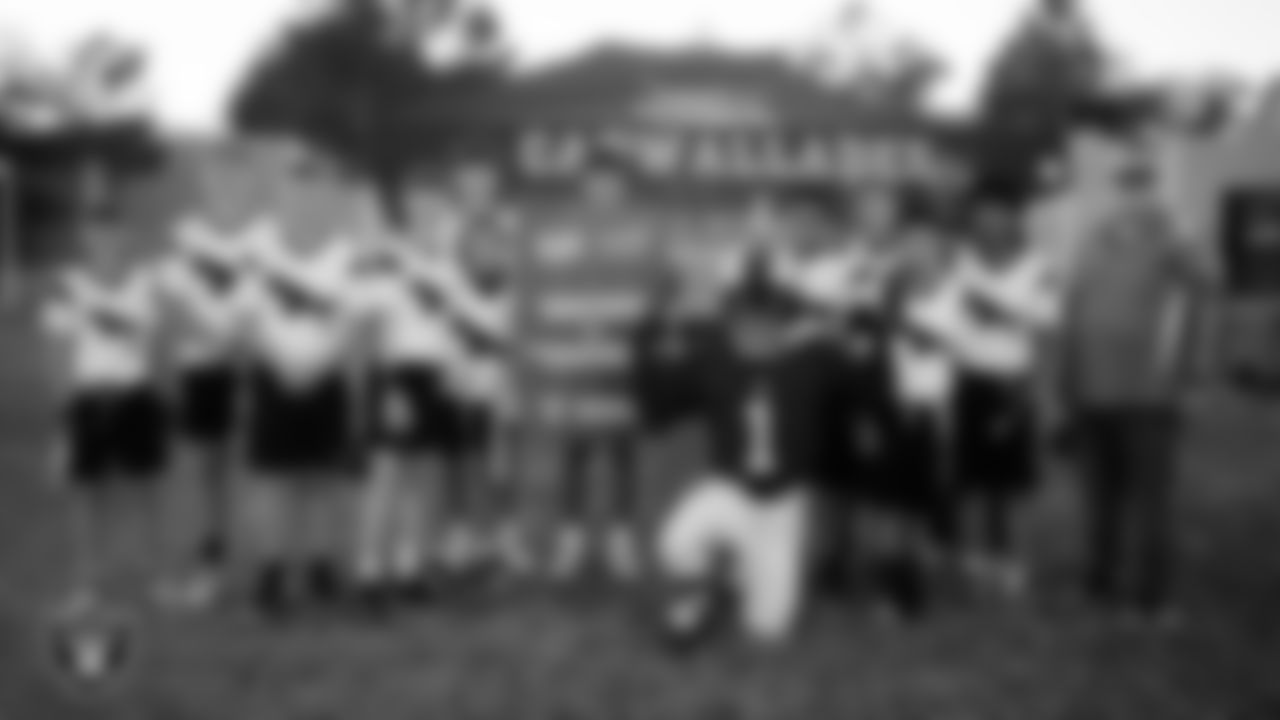 Raider Rusher poses for a photo with the Charles Hughes Middle School flag football team after the Las Vegas Raiders' Middle School Flag Football Showcase game at Ralph Cadwallader Middle School.
