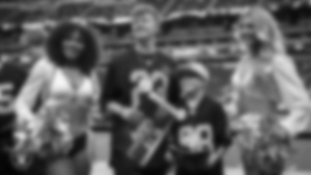 Alex Parraga and Clay Charlson from the Make-A-Wish Foundation pose for a photo with Raiderettes Makenna P. and Camryn before the Las Vegas Raiders' regular season home game against the New England Patriots at Allegiant Stadium.