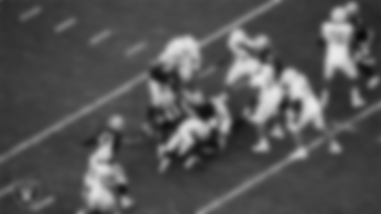 Las Vegas Raiders linebacker Robert Spillane (41), defensive end Andre Carter II (99) and defensive tackle Jonah Laulu (96) make a tackle during the regular season home game against the Los Angeles Chargers at Allegiant Stadium.